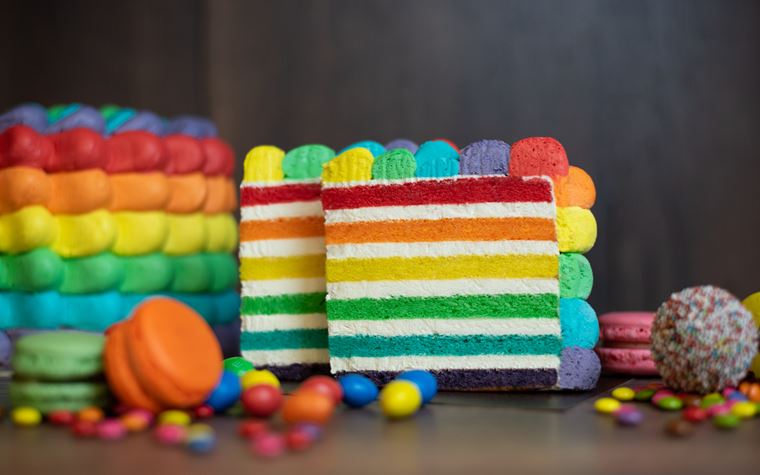 Rainbow cake, una torta davvero spettacolare per una festa speciale. 6 strati di cake colorati farciti con crema di formaggio fresco, coperta da mousse al ciocc. bianco nei 6 colori dell'arcobaleno 