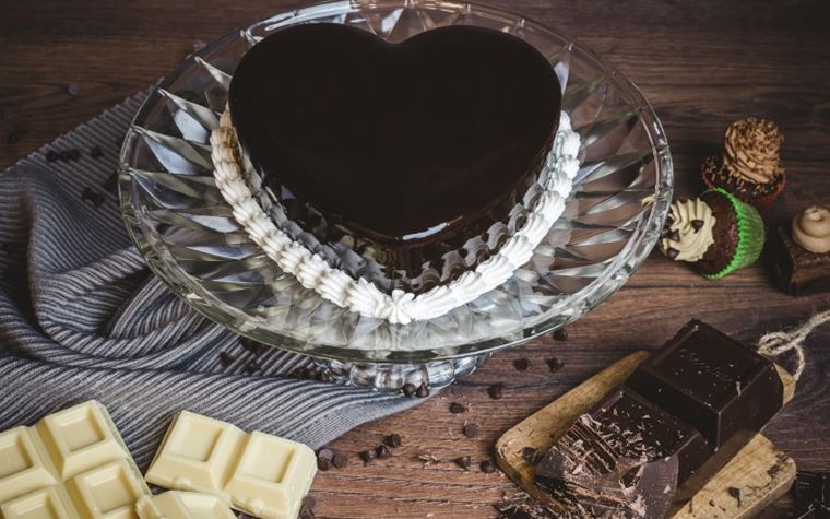 Mousse a forma di cuore in qualsiasi gusto, in questo caso cioccolato bianco e fondente glassata nera a specchio.